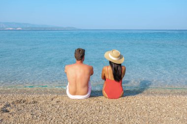 Hırvatistan 'ın Brac Adası' nın berrak sularında, ılık yaz güneşinin tadını çıkaran bir çift, huzurlu bir anın tadını çıkarıyor. Zlatni Rat Sahili çakıl taşları rahatlamak için mükemmel bir yer.