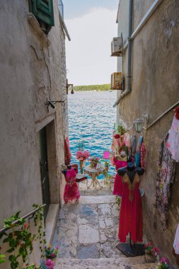 Rovinj 'deki canlı bir ara sokakta renkli elbiseler, kaldırımlı basamakları kaplayarak köpüklü sulara çıkıyor.