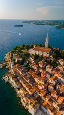 Rovinj 'in büyüleyici mimarisi, sakin Adriyatik Denizi' nin kıyı şeridinde usulca tur atarak canlı renklerle dolu pitoresk bir kıyı manzarası yaratmasıyla gün batımının ılık parıltısında parıldıyor..
