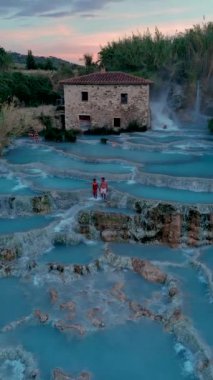 Tuscany, İtalya 'da büyüleyici kaplıcaların ve şelalelerin bulunduğu büyüleyici Satürn Termal Hamamlarını keşfedin. Saturnia 'nın kaplıcalarında bir çift kadın ve erkek.