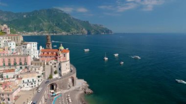 İtalyan Amalfi Sahili 'nin güzel bir köyü olan Atrani' nin göz kamaştırıcı hava manzarasını yaşayın. Etrafı yemyeşil dağlarla çevrili ve kalbi büyüleyen parlak mavi bir deniz.