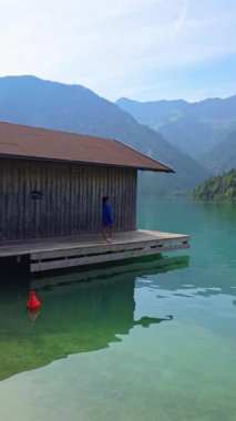 Avusturya 'daki görkemli Tyrolean dağlarının arasına kurulmuş rahat bir kulübeyle Plansee Gölü' nün güzelliğini görün.