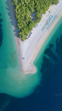 Hırvatistan 'ın Brac Adası' ndaki Zlatni Rat Sahili 'nin unutulmaz hava manzarasının tadını çıkarın. Turkuaz suları ve yemyeşil yeşilliği rahatlamak ve keşfetmek isteyen maceraperest gezginler için bir cennet yaratıyor.