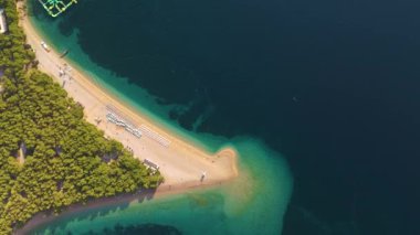 Berrak suların ılık güneş altında dinlenmeye ve keşiflere izin verdiği canlı ağaçlar arasında yuva yapmış Brac Adası Hırvatistan 'ın pitoresk bir kumsalın huzurunu yaşayın.