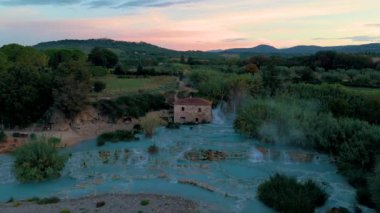 Sakin atmosferi, büyüleyici taş bir evin etrafındaki canlı termal yaylar gibi hissedin. Terme di Saturnia, Saturnia 'daki jeotermal sülfür kaynakları, İtalya' daki Toscane kaplıcaları.