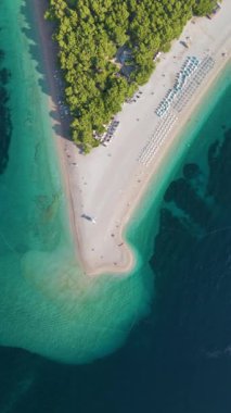 Yumuşak kumun, canlı turkuaz suların ve yemyeşil ağaçların bulunduğu tenha bir plajın huzur dolu güzelliğini hissedin. Brac Adası Hırvatistan