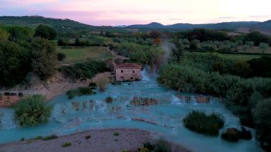 Güneşin doğuşunda buharlı doğal termal bahar havuzu, İtalya 'nın yemyeşil renkli İtalya kırsalındaki Terme di Saturnia..