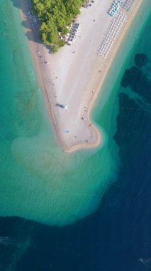 Bu hava fotoğrafı Hırvatistan 'ın Brac Adası' ndaki çarpıcı Zlatni Rat Sahili 'ni gösteriyor. Berrak suları ve eşsiz karasuları ziyaretçileri ve doğa severleri cezbediyor. Bu da onu bir ziyaret noktası yapıyor.