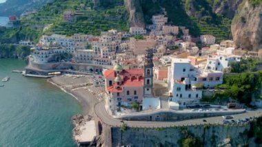 Amalfi Atrani kıyı şeridinin göz kamaştırıcı güzelliğini yaşayın. Renkli evler parlak mavi suların üzerindeki kayalıklara tutunuyor. Bu güzel kasabadaki huzurlu manzaranın tadını çıkarın..