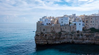 Dalgalar yavaşça Puglia 'nın eski kireçtaşı kayalıklarına çarpıyor, beyaz boyalı binalar kıyıya yapışıyor, doğa ve mimariyi parlak mavi bir gökyüzü altında harmanlıyor. Polignano a Mare Italy