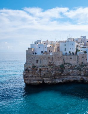 Kayalıklara kurulmuş Puglia 'nın büyüleyici beyaz binaları Adriyatik Denizi' nin dingin mavi sularına, Polignano a Mare İtalya 'ya bakıyor.