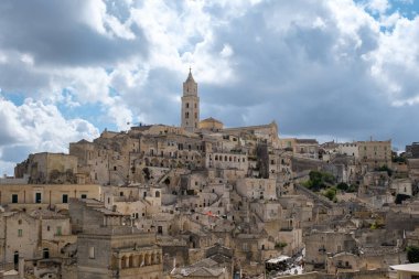 Bir tepeye kurulmuş Matera, yüzyıllardır süren taş evleri ve kiliselerini sergiliyor. Bulutlar gökyüzünde sürüklenirken doğal ışık altında yüzerek ziyaretçileri cezbeden büyüleyici bir atmosfer yaratıyor..