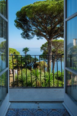 Güneşli balkon, yemyeşil ve canlı palmiye ağaçları çerçeveli Amalfi Sahili 'nin büyüleyici bir manzarasını sunuyor. Huzurlu sahil güzelliğinin tadını çıkarmak için mükemmel bir dinlenme yeri. Ravello İtalya