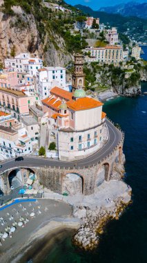 Colorful houses cling to the dramatic cliffs of the Amalfi Coast, showcasing a blend of historical architecture and stunning ocean views, Atrani Italy clipart