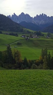 Sarmal yeşil tepelerin çarpıcı dağ zirveleriyle buluştuğu Dolomitlerin nefes kesici güzelliğini tecrübe edin. Val di Funes Köyü Santa Maddalena İtalya
