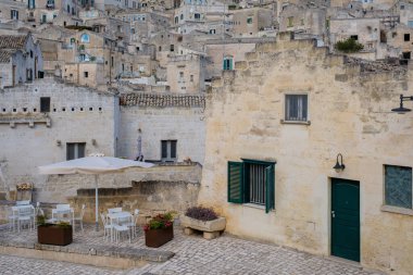 Matera, İtalya 'nın göbeğinde, güzel taş binalar dik bir şekilde yükseliyor, bu da ilginç açık hava yemek alanı için çarpıcı bir zemin oluşturuyor..