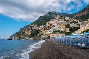 Positano 'daki tepenin yamacına yapışmış renkli evler Amalfi Sahili' nin güzelliğini yakalarken dalgalar yavaşça kumlu sahile vurur. İtalya 'nın sahil cazibesine mükemmel bir kaçış..