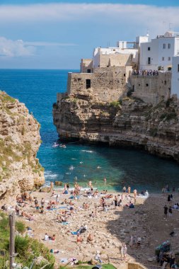Polignano a Mare Ziyaretçileri, İtalya 'nın Puglia kentindeki pitoresk bir koyda yaz güneşinin tadını çıkarıyor. Temiz turkuaz su sahile gidenleri cezbederken büyüleyici kıyı yapıları da güzel bir zemin oluşturuyor..
