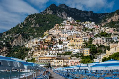 Amalfi Sahili boyunca yuva yapmış renkli evler dik yamaçlara tırmanırken, güneşli şezlonglar çakıllı plajları sıralıyor ve ziyaretçileri nefes kesen Akdeniz manzaralarında dinlenmeye ve yıkanmaya davet ediyor..
