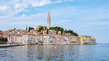 Rovinj, hareketli binaların sakin suları yansıtıp pitoresk bir sahil kaçışı yaratmasıyla gün ışığında güneşleniyor. Tarihi çan kulesi büyüleyici kasabanın üzerine yükseliyor ve cennet atmosferini güçlendiriyor..