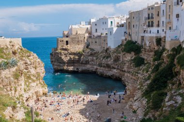 Büyüleyici bir şehir olan Polignano a Mare Italy 'de, ziyaretçiler yüksek kayalıkların arasındaki kumlu kıyılarda dinleniyorlar. Gök mavisi sular yerli halkı ve turistleri sıcak güneşin ve manzaranın tadını çıkarmaya davet ediyor..