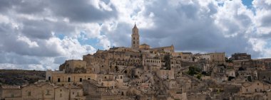 Matera göz kamaştırıcı bir ihtişam içinde dalgalanan bulutların altında antik taş binalarını sergiliyor. Puglia İtalya