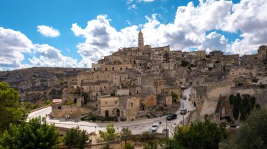 Matera İtalya 'da, ziyaretçiler tarihi taş binaları ve çarpıcı manzaraları keşfediyorlar, hepsi uçsuz bucaksız, noktalı gökyüzünün altında, bu antik İtalyan kasabasının cazibesini yakalıyorlar..
