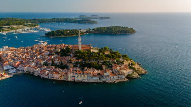 Hırvatistan 'ın Rovinj kentinin bu büyüleyici manzarasında kıyı boyunca renkli binalar yer alırken, sakin sular sıcak günbatımı renklerini yansıtıyor, keşif ve hayranlık uyandırıyor..