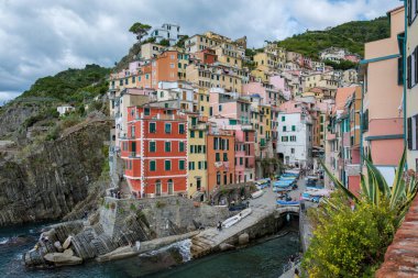 Limanda sallanan balıkçı tekneleri gibi renkli binalar Cinque Terre 'nin engebeli kayalıklarına tutunuyor. İtalya 'nın Cinque Terre kentindeki Riomaggiore sahili İtalya' nın özünü yansıtıyor..