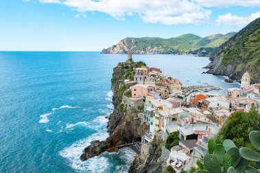 Parlak bir gökyüzü altında dalgalı tepeler ve canlı kıyı yaşamlarıyla çevrili açık deniz kıyısındaki uçurumlara yapışmış canlı binaların bulunduğu nefes kesici Cinque Terre 'yi keşfedin. Vernazza İtalya