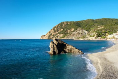 Güneş, Cinque Terre kıyısındaki çarpıcı kaya oluşumlarını vurgulayarak sakin suların üzerine altın ışınlar saçar. Monterosso İtalya