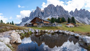 Dolomitlerin heybetli tepeleri, dingin alp çayırlarının üzerinde, serin bir gölde parıldayan çarpıcı yansımaları, Dolomites Val Di Funes İtalya 'da