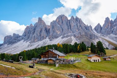 Dolomitlerin nefes kesen zirveleri, yemyeşil çayırlar ve İtalya 'daki Geisleralm Dolomitleri Val Di Funes' a yuva yapmış büyüleyici ahşap kireçlerin üzerine çarpıcı bir şekilde yükselir.
