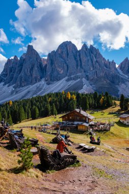 Visitors enjoy a relaxing day in the Dolomites, surrounded by majestic mountains and vibrant autumn colors. Geisleralm Dolomites Val Di Funes in Italy Adolf Munkel Trail in Puez Odle Nature Park clipart