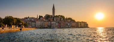 Güneş Rovinj 'in üzerinde batarken, ılık ışık rıhtım boyundaki renkli binaları yıkıyor ve güzel bir manzara yaratıyor.
