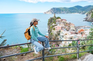 Bir gezgin Cinque Terre 'nin çarpıcı sahil manzarasına hayran kalarak tırabzanda durur. Vernazza İtalya