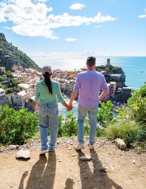 Canlı bir sahil kasabası olan Cinque Terre 'ye bakan bir çift, Güneş' in birlikte el ele tutuşmak için mükemmel bir zamanı simgelediği bir güzellikle çevrelerinin güzelliğine dalmış durumda. Vernazza İtalya