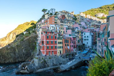 Altın saat uçurum kenarını sararken Cinque Terre 'nin ışıl ışıl limanından büyüleyici renkli evler yükseliyor. İtalya Cinque Terre 'de Riomaggiore