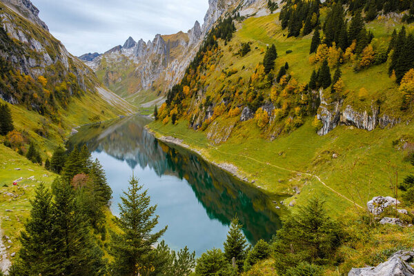 Nestled in the heart of Appenzell, Falensee glimmers with autumn colors as trees line the banks.