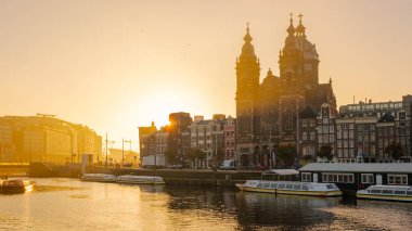 Zaandam Hollanda 23 Ekim 2024, sonbaharda güneş batarken Amsterdam 'ın kanalları sıcak renklerle parıldıyor ve çarpıcı tarihi binaları aydınlatıyor..