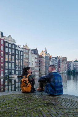 Güneş ufkun altına batarken, birkaç çift Amsterdam 'ın sakin kanallarında sakin bir anı paylaşıyor. Onları çevreleyen canlı sonbahar renkleri, tarihi Hollanda mimarisinin cazibesini vurguluyor..