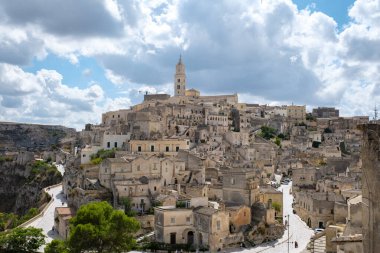 Büyüleyici Matera kasabası, dünyanın dört bir yanından ziyaretçilerin ilgisini çeken tarihi güzelliği ve büyüleyici manzarayı gözler önüne seren dramatik bulutlar karşısında taş mimarisini gözler önüne seriyor..