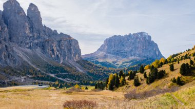 Sonbahar renkleri Dolomitleri sarar, gür ormanları ve parlak bir gökyüzünün altındaki yüksek uçurumlarla. Doğanın güzelliği sakin bir vadide sergilenir, nefes kesici manzaralar arasında keşif ve maceraya davetiye çıkarır..