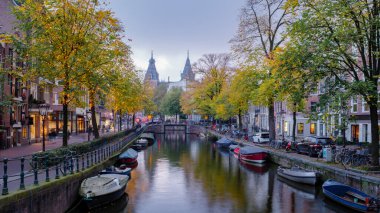 Altın yapraklar, sakin suların tarihi mimariyi yansıttığı ve rahat teknelerin usulca sürüklendiği bir sonbahar akşamında Amsterdam 'ın huzurlu kanallarını çerçeveler..