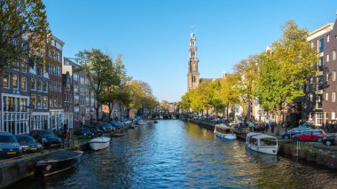 Amsterdam 23 Ekim 2024, Amsterdam 'ın sakin kanallarında kayıklar yavaşça süzülürken altın yapraklar sallanıyor. Hava açık ve yerliler suya yansıyan canlı sonbahar renklerinin tadını çıkarıyorlar..