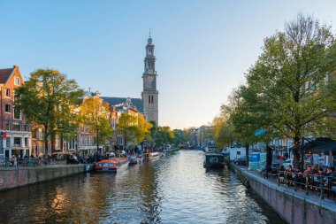 Amsterdam 23 October 2024, As daylight wanes, the canals of Amsterdam come alive with the warm hues of autumn. Trees show off their colorful leaves while people enjoy leisurely strolls and boat rides clipart