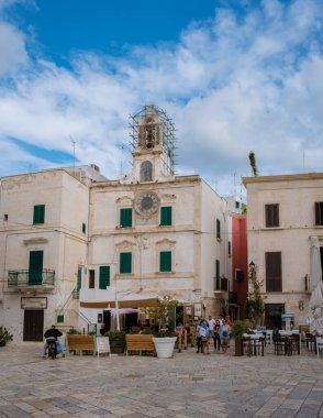 Polignano a Mare İtalya 18 Eylül 2024 Puglia 'nın göbeğinde, yerli halk ve ziyaretçiler tarihi binalarla çevrili büyüleyici bir meydanın etrafında toplandılar.. 
