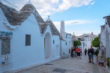 Alberobello İtalya 18 Eylül 2024 Alberobello 'nun büyüleyici sokaklarında gezinen ziyaretçiler, konik çatıları olan ikonik trulli evlere hayran kaldılar..