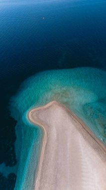 Brac Adası kumlu yarımadası, dingin bir günbatımında huzur ve doğal güzelliği çağrıştıran canlı turkuaz denize doğru yavaşça kıvrılıyor. Zlatni Rat Sahili Hırvatistan