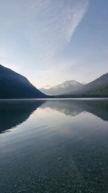 Şafak sökerken gölün sakin suları etrafını saran görkemli dağları yansıtır. Yumuşak ışık huzur getirir, doğadaki sükunet anları kucaklaşır. Plansee Avusturya